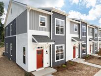 Modern townhome community with gray and white siding, red doors, and landscaping at 2122 Acclaim St, Charlotte, NC 28205