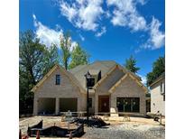 Charming new construction home featuring a gray brick facade, two-car garage, and a well-manicured lawn at 1211 Royal Prince Ct, Charlotte, NC 28211
