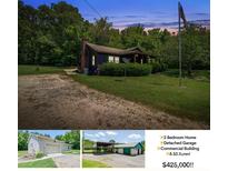 Charming exterior view of home with gravel driveway, mature trees and American flag in the yard at 12770 Bringle Ferry Rd, Richfield, NC 28137
