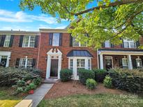 Charming brick townhome featuring a black front door and meticulously maintained landscaping at 20528 Harbor View Dr, Cornelius, NC 28031
