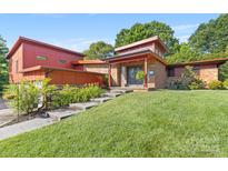 Inviting home with red wood and brick exterior, mature landscaping, and stepped pathway to the front door at 640 Davie Ave, Statesville, NC 28677