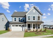 Two-story house with gray siding, white garage door, and landscaped lawn at 6018 Valehaven Pl # 0070, Charlotte, NC 28269