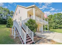 Two-story house with wrap-around porch, attached garage, and American flag at 556 Peaceful Creek Dr, York, SC 29745