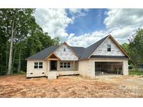 Under-construction brick home with a spacious attached garage, black roof, and covered front porch, set in a wooded area at 1500 Crowders Creek Rd, Gastonia, NC 28052
