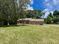 Charming brick home with a well-manicured lawn and inviting front porch, perfect for relaxing outdoors at 2310 Montford Nw Ave, Concord, NC 28027