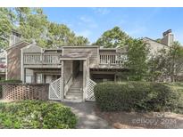 Charming two-story townhouse featuring well-maintained landscaping, and a private entrance with stairs and a deck at 1600 Sharon W Rd # 11, Charlotte, NC 28210