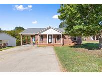 Charming single-story brick home featuring a covered carport and inviting front porch at 927 Kearney Dr, Shelby, NC 28152