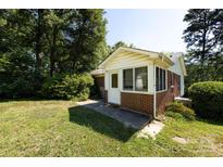 Charming sun room addition with brick base and lots of natural light shining onto the lawn at 2001 Mcdonald Dr, Charlotte, NC 28216