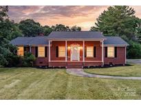 Brick ranch house with covered porch and landscaped yard at 2909 Eastway Dr, Statesville, NC 28625