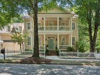 Charming two-story home with a double porch, a white picket fence, and a well-manicured front yard at 927 Dericks Xing, Fort Mill, SC 29708