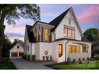 Striking two-story home with a painted brick exterior, black trim and a detached garage at 626 Concord Rd, Davidson, NC 28036