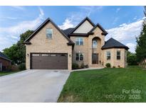 A beautiful home with a brick exterior, manicured lawn, and a two-car garage at 1358 37Th Avenue Ne Pl, Hickory, NC 28601