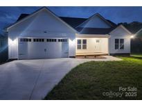 Charming single-story home with a two-car garage, manicured lawn, and modern white siding at 9609 Stokes Ferry Rd, Gold Hill, NC 28071
