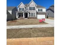 Charming two-story home with a brick and stone facade, complemented by an attached two car garage at 121 Clawton Loop, Mooresville, NC 28115