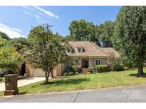 Brick house with a large yard, mature trees, and a two-car garage at 426 Saint Michaels Way, Fort Mill, SC 29708