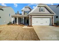 Two-story home with gray siding, stone accents, and a two-car garage at 5308 Verona Rd # 75, Charlotte, NC 28213