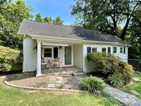 Charming white cottage with a stone walkway, porch, and well-manicured landscaping at 1863 Hilltop Cir, Gastonia, NC 28054