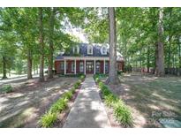 Charming brick home featuring a welcoming front porch, dormer windows, and a meticulously landscaped yard at 3814 Watson Church Rd, Monroe, NC 28110