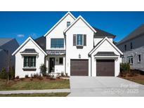 A beautiful two-story home shows a well manicured lawn, a two car garage, and a white brick facade at 4031 Pritchard Pl, Fort Mill, SC 29715