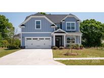 Charming two-story home features a light blue exterior, a two-car garage, and manicured front lawn at 4684 Hopsack Dr # Cal0105, Indian Trail, NC 28079