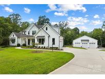 White farmhouse with attached three-car garage and spacious driveway at 5811 Kristi Ln, Midland, NC 28107