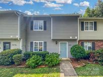 Charming townhome featuring a light blue front door, gray siding and well-maintained landscaping at 6003 Heath Valley Rd, Charlotte, NC 28210