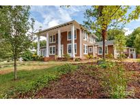 Two-story brown house with white columns and a landscaped yard at 903 W Franklin St, Monroe, NC 28112