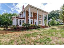 Side view of a charming two-story house with a landscaped yard at 903 W Franklin St, Monroe, NC 28112