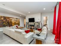 Bright living room features a cozy fireplace, tile accents, and comfortable seating at 3020 Poplar Hill Rd, Charlotte, NC 28270