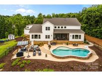 Stunning backyard with a beautiful pool, gazebo, patio, and lush landscaping perfect for entertaining at 127 Tradition Ln, Mooresville, NC 28115