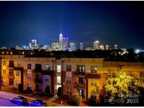 Night view of the Charlotte skyline from an apartment building with illuminated buildings and clear dark sky at 12119 Brooklyn Ave, Charlotte, NC 28204
