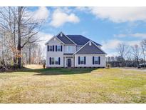 Two-story house with gray siding, dark shutters, and a grassy yard at 824 N Rocky River Rd, Monroe, NC 28110