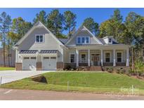 Two-story house with a front porch, two-car garage, and nicely landscaped yard at 1025 Patterson Farm Rd, Mooresville, NC 28115