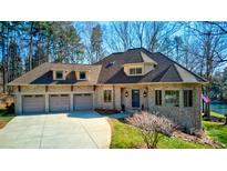 Charming stone home with a three-car garage, well manicured lawn and mature trees at 301 Agnew Rd, Mooresville, NC 28117