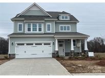 Charming two-story home featuring a spacious two car garage, covered porch, and beautiful light green siding at 4808 Glen Stripe Dr # Cal0036, Indian Trail, NC 28079