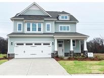 Charming two-story home with attached garage, front porch, stone accents, and manicured lawn at 4808 Glen Stripe Dr # Cal0036, Indian Trail, NC 28079