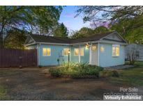 Charming single-story home featuring light blue siding, well-manicured landscaping, and welcoming front entrance at 209 21St St, Newton, NC 28658