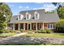 Brick home with a front porch and landscaped yard at 721 Orphanage Rd, Concord, NC 28027