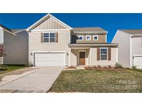 Two-story house with beige siding, white garage door, and landscaped lawn at 1610 Cannonball Ln, Bessemer City, NC 28016