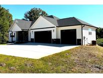 New construction home featuring a white exterior, stone accents, and a spacious three-car garage at 117 Hatford Ct, Statesville, NC 28625