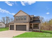 Beautiful two-story home featuring stone accents, three-car garage, covered porch, and manicured lawn at 171 Heartland Dr # 7, Rock Hill, SC 29732