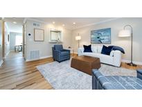 Bright living room featuring a white sofa, blue accents, modern art, and hardwood floors at 430 Queens Rd # 712, Charlotte, NC 28207