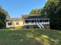 Brick ranch home with front porch and landscaped yard at 475 Cornerstone Dr, Taylorsville, NC 28681