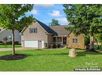 Two-story house with stone accents, attached garage, and landscaped lawn at 125 Ariel Dr, Mooresville, NC 28117