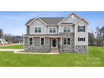 Stunning two-story home featuring a stone facade, gray siding, multiple windows, and a well-manicured lawn at 133 Jentri Way, Mooresville, NC 28115