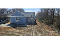 Charming light blue home with gray roof, manicured lawn, and inviting front entrance at 2280 Dale Earnhardt Blvd, Kannapolis, NC 28083