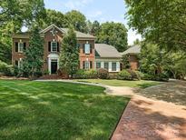 Brick two-story house with landscaped lawn and brick walkway at 4301 Fairview Oaks Dr, Charlotte, NC 28211