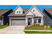 Two-story home with gray siding, stone accents, and a two-car garage at 1314 Idyllic Ln, Waxhaw, NC 28173