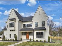 Stunning two-story home with a white brick facade and a charming front porch at 4839 Fairheath Rd, Charlotte, NC 28210