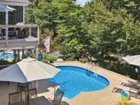 Inviting pool with patio and deck, umbrella, and lounge chairs at 418 Sebring Ct, Belmont, NC 28012